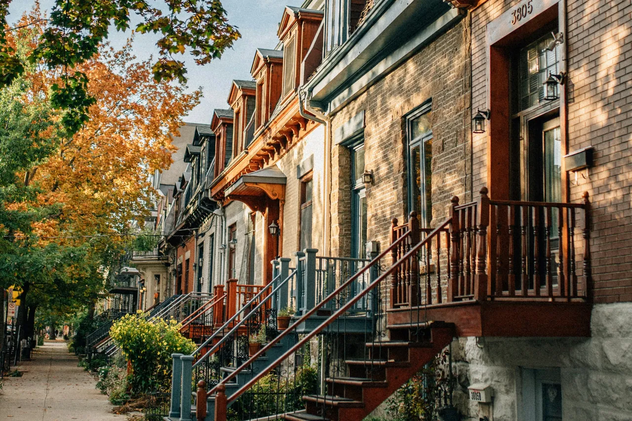 Rangée de maisons montréalaises avec escaliers extérieurs, en automne
