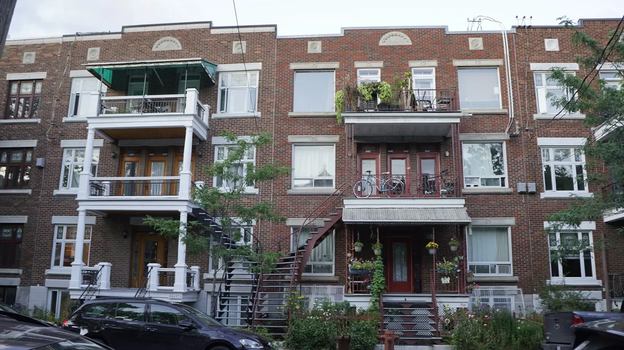 Une rangée de triplex en brique à Montréal, avec balcons et escaliers extérieurs